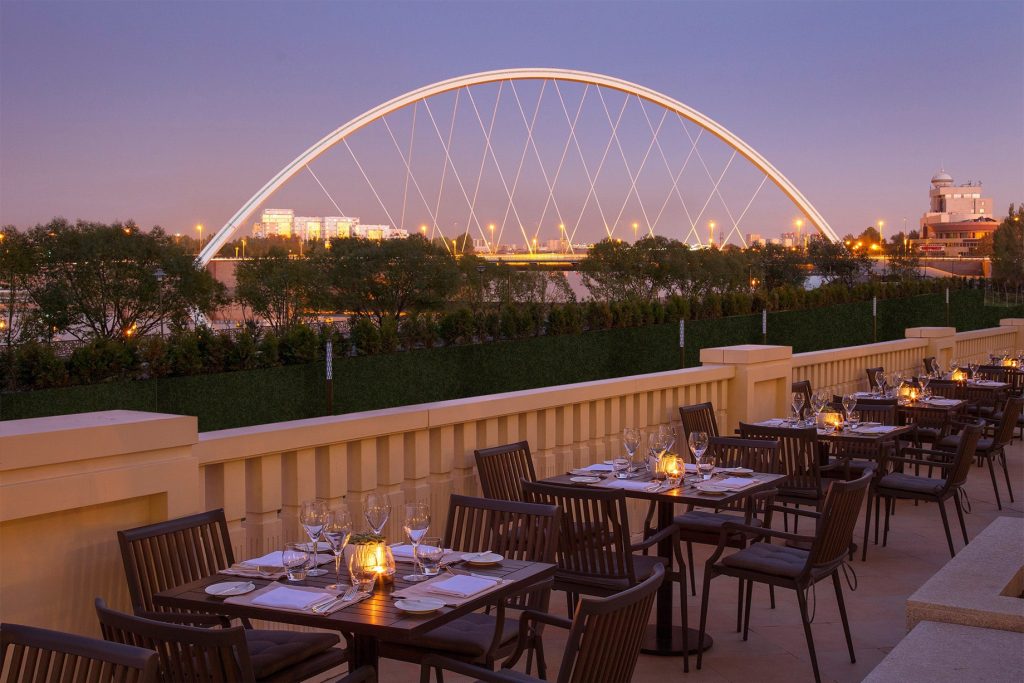 The St. Regis Astana Hotel - Astana, Kazakhstan - Exterior Terrace Restaurant Tables Night