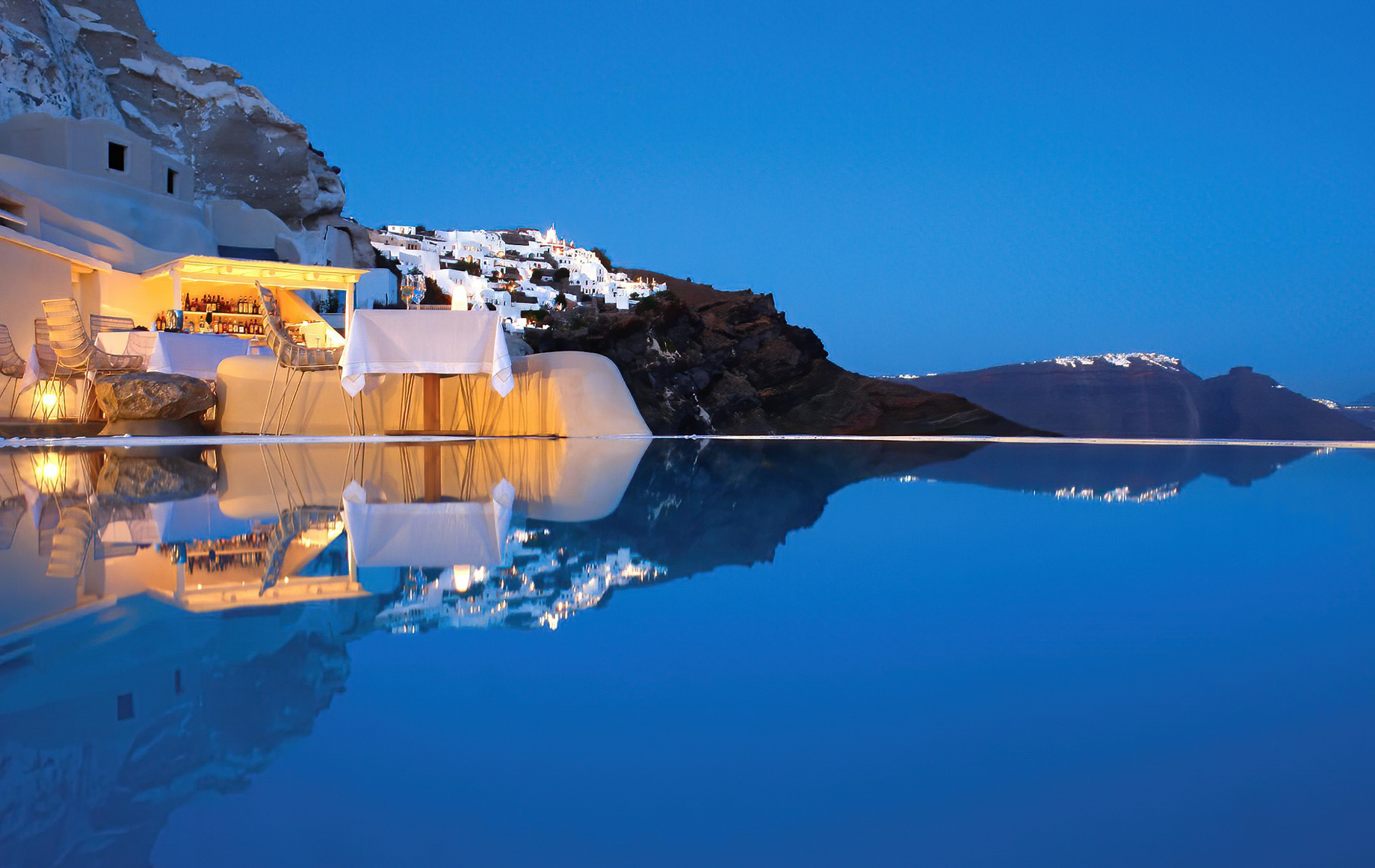 Mystique Hotel Santorini – Oia, Santorini Island, Greece - Cliffside Pool Deck Dining Tables