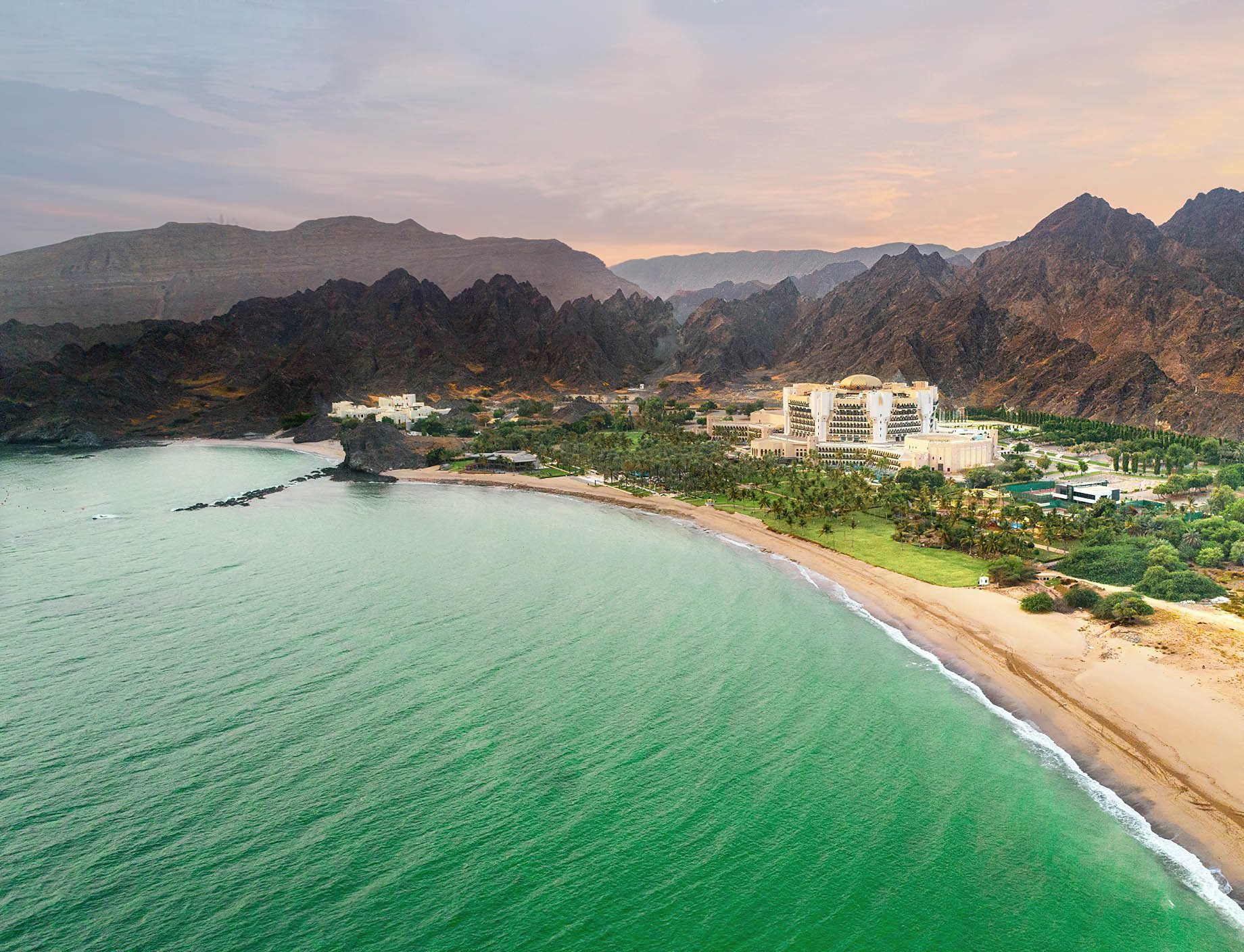 Al Bustan Palace, A Ritz-Carlton Hotel – Muscat, Oman – Hotel Aerial View Sunset