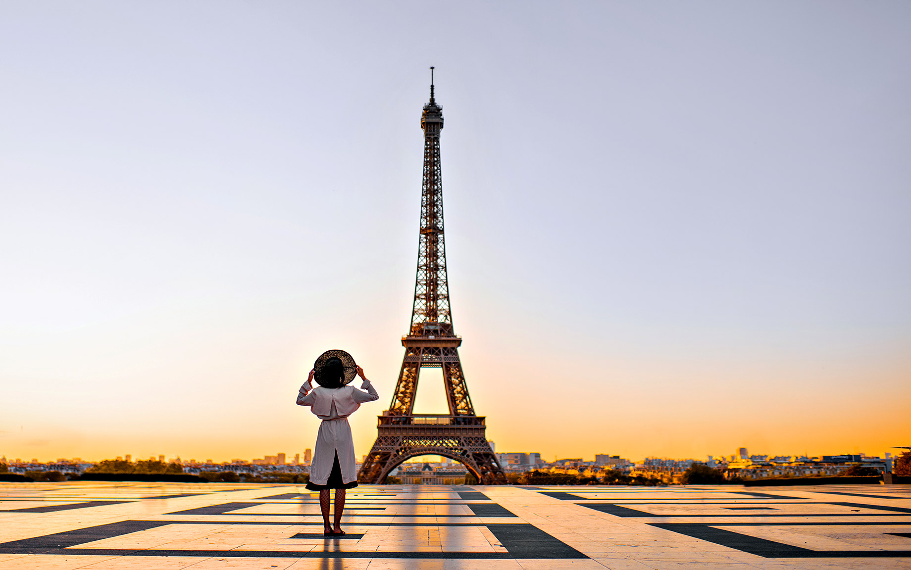 A Woman Enjoying a Sunset View of the Eiffel Tower in Paris, France