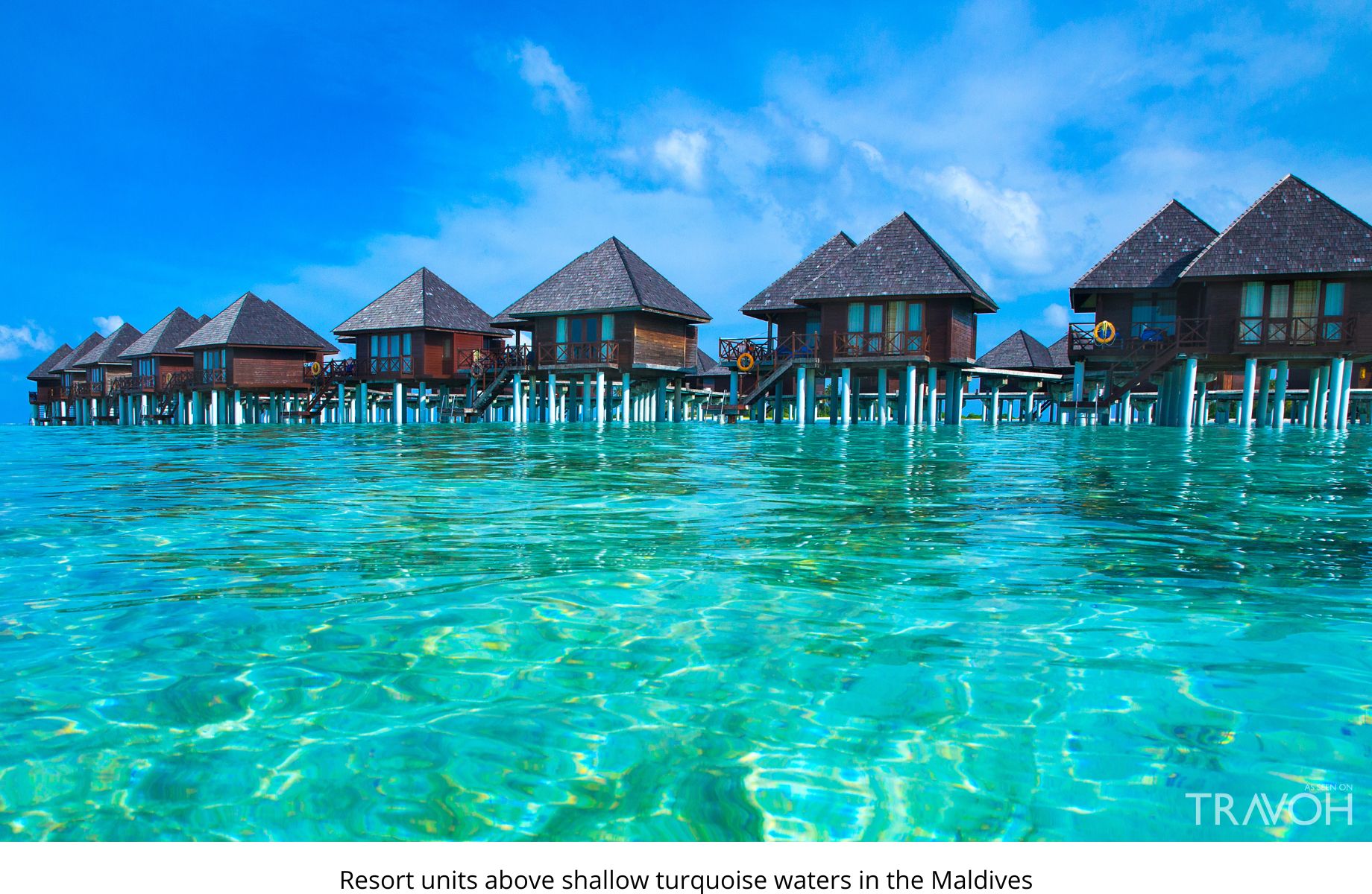 Resort units above shallow turquoise waters in the Maldives