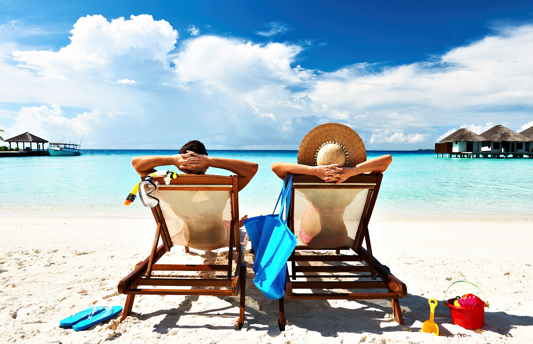 Couple In Lounge Chairs On A Beach