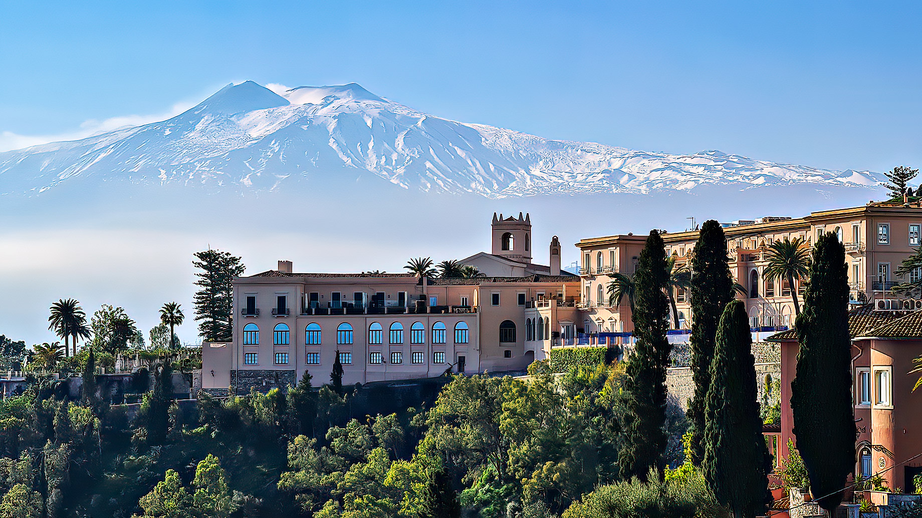 Luxury San Domenico Palace Hotel with panoramic view on snow capped Mount Etna