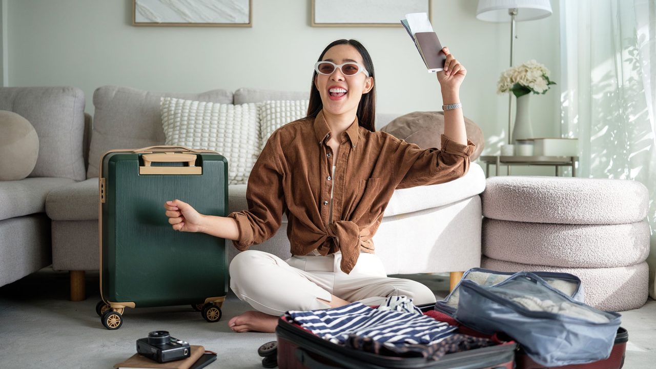 Woman Holding Passport and Ticket with Travel Luggage Packed