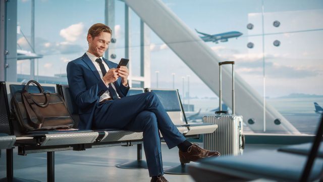 Man in Suit Waiting in Airport Terminal for Flight