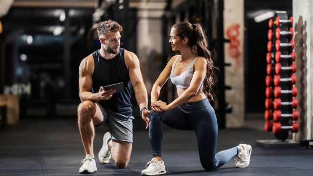 Personal Fitness Trainer Engaging with His Female Client in the Gym