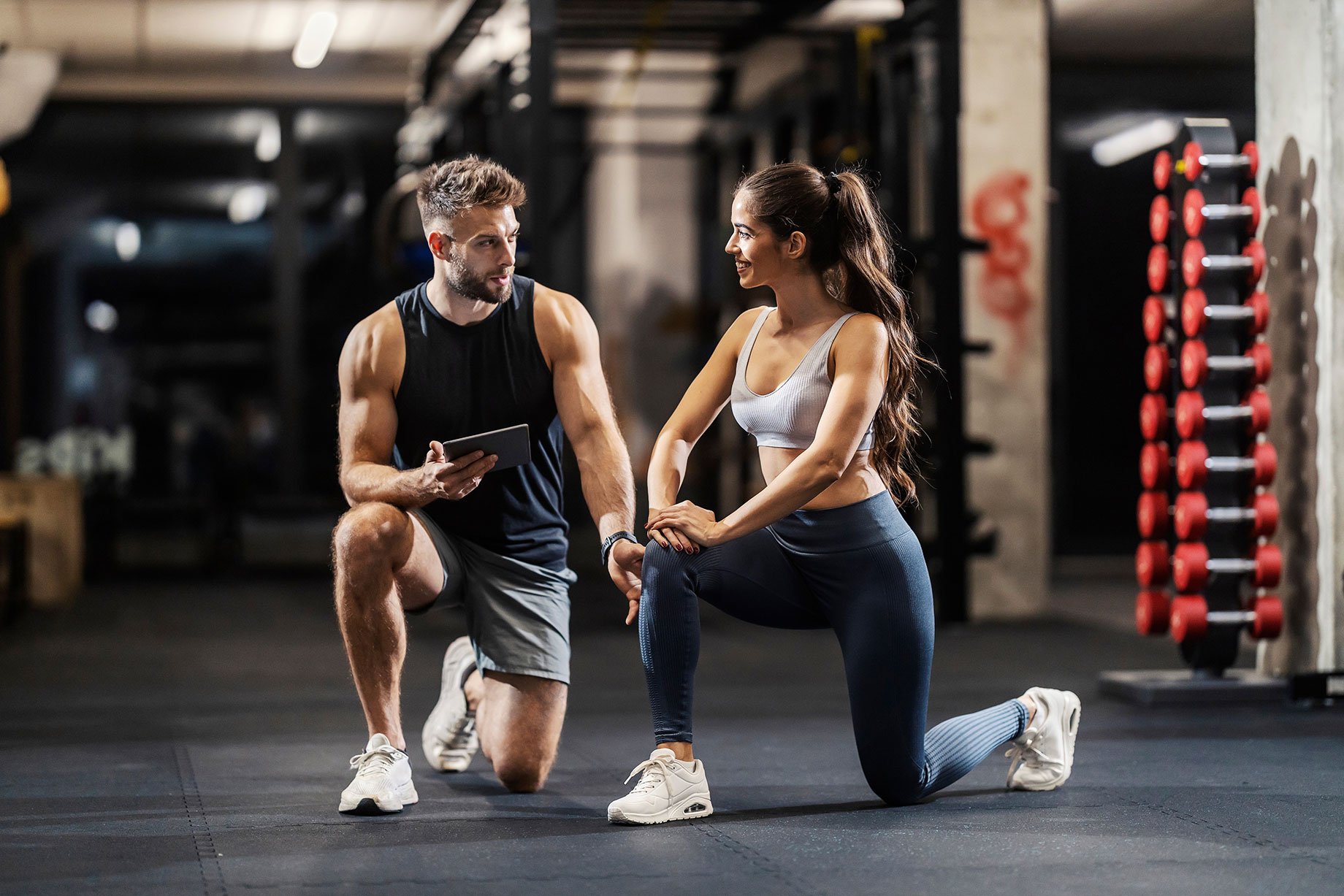 Personal Fitness Trainer Engaging with His Female Client in the Gym