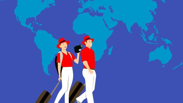 Illustration of a man and woman in red shirts and hats, pulling suitcases while walking in front of a blue world map background.