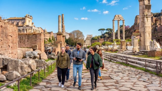 Private tour group walking along a stone path through ancient Roman ruins.